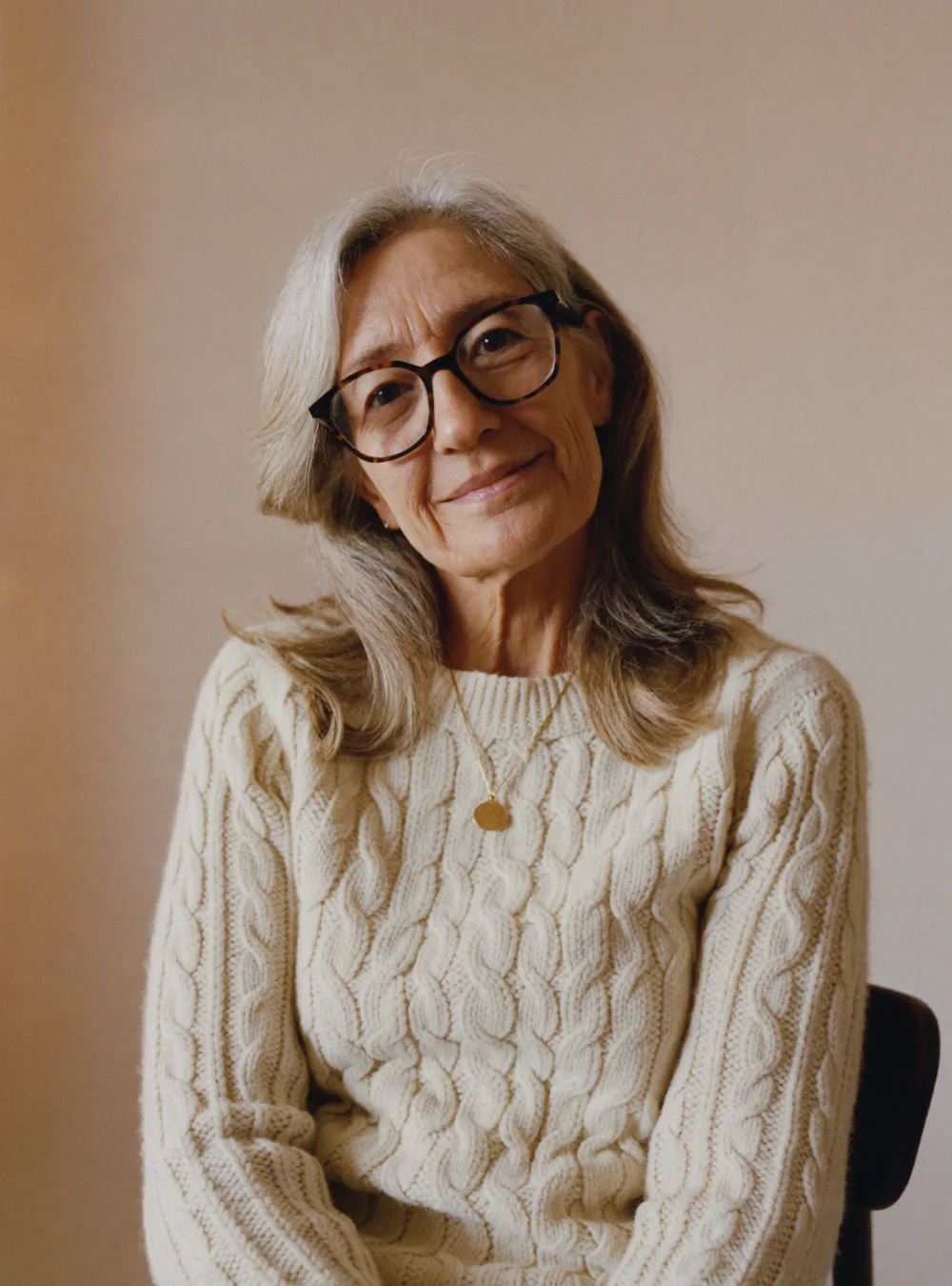 Portrait of Susan Hartley in a cream cable-knit sweater, smiling gently